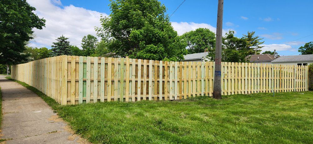 Long stretch of new shadow box fence beside a sidewalk